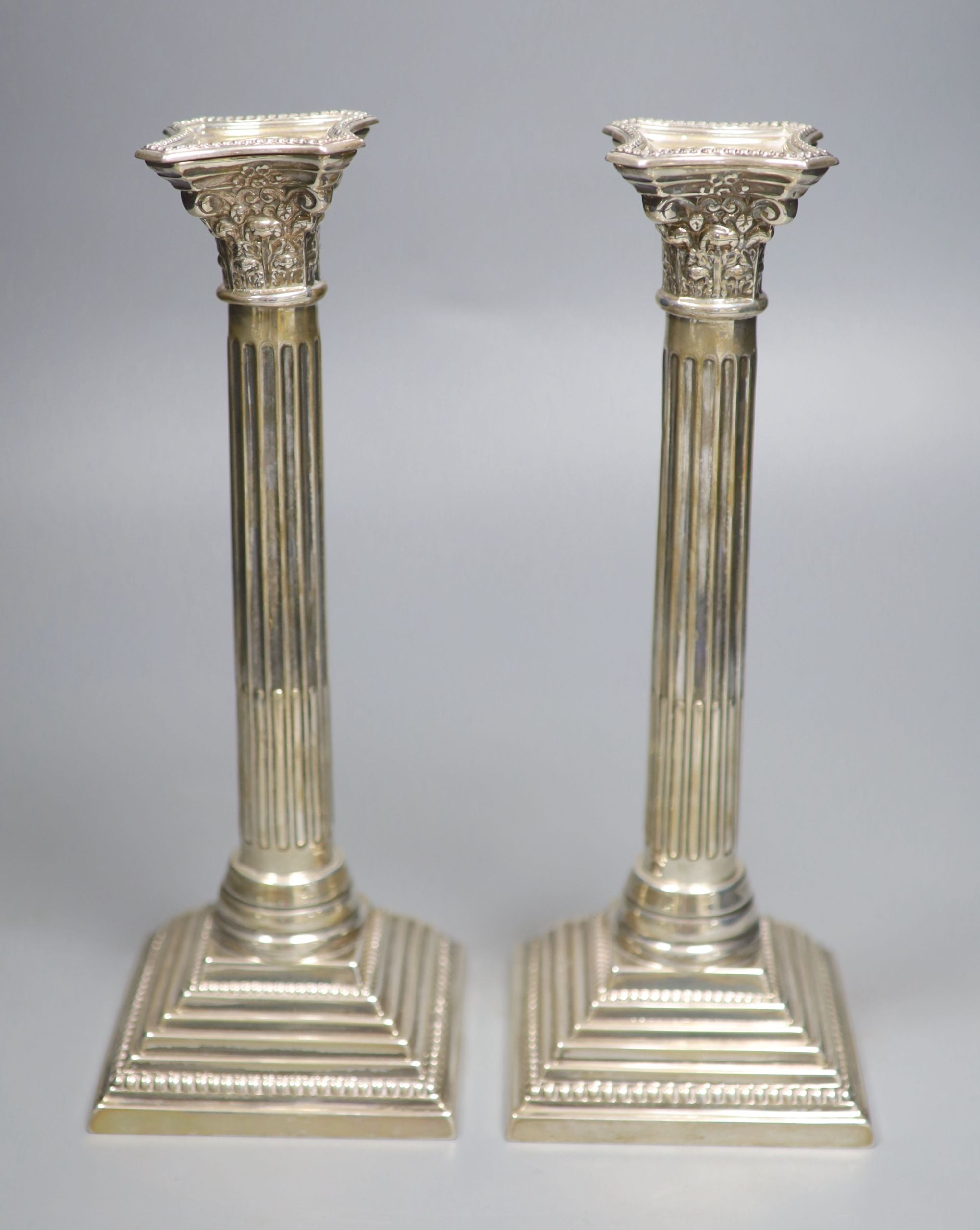 A pair of George VI silver corinthian column candlesticks, RS, London, 1950, height 26.8cm, 19oz.